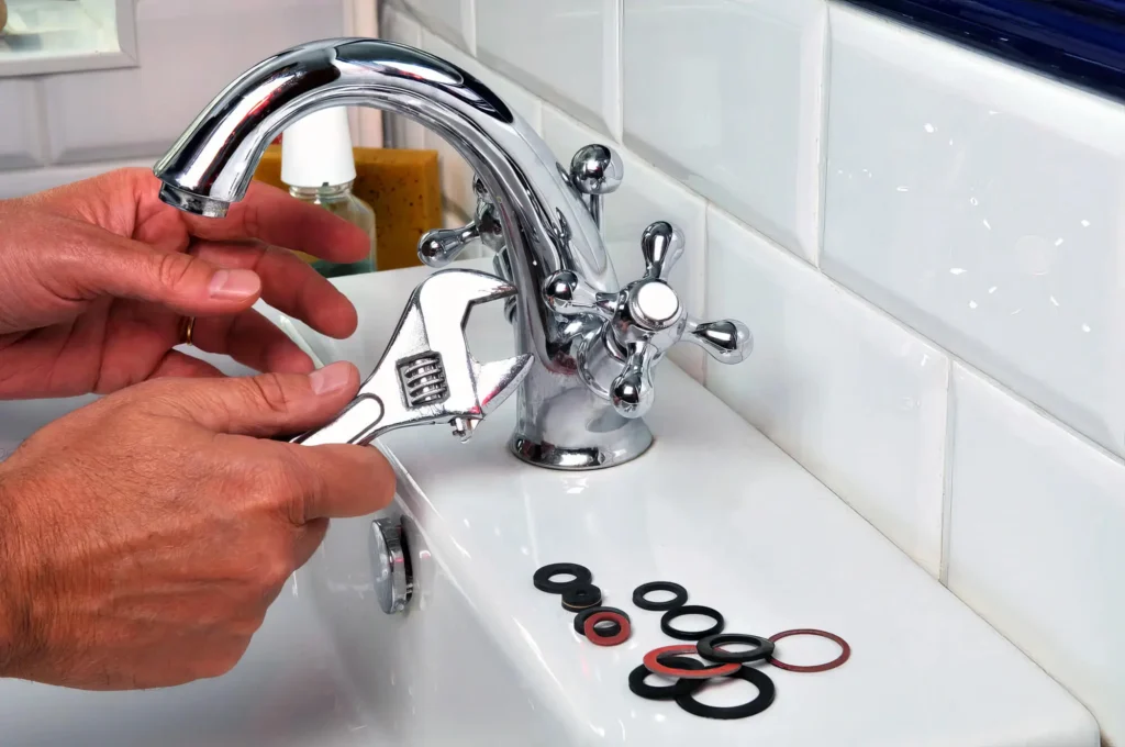 Plumber performing maintenance on a bathroom faucet in Windsor