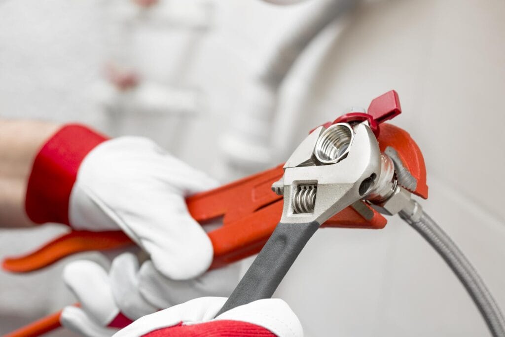 Plumber holding pipe wrenches for an emergency repair in Windsor